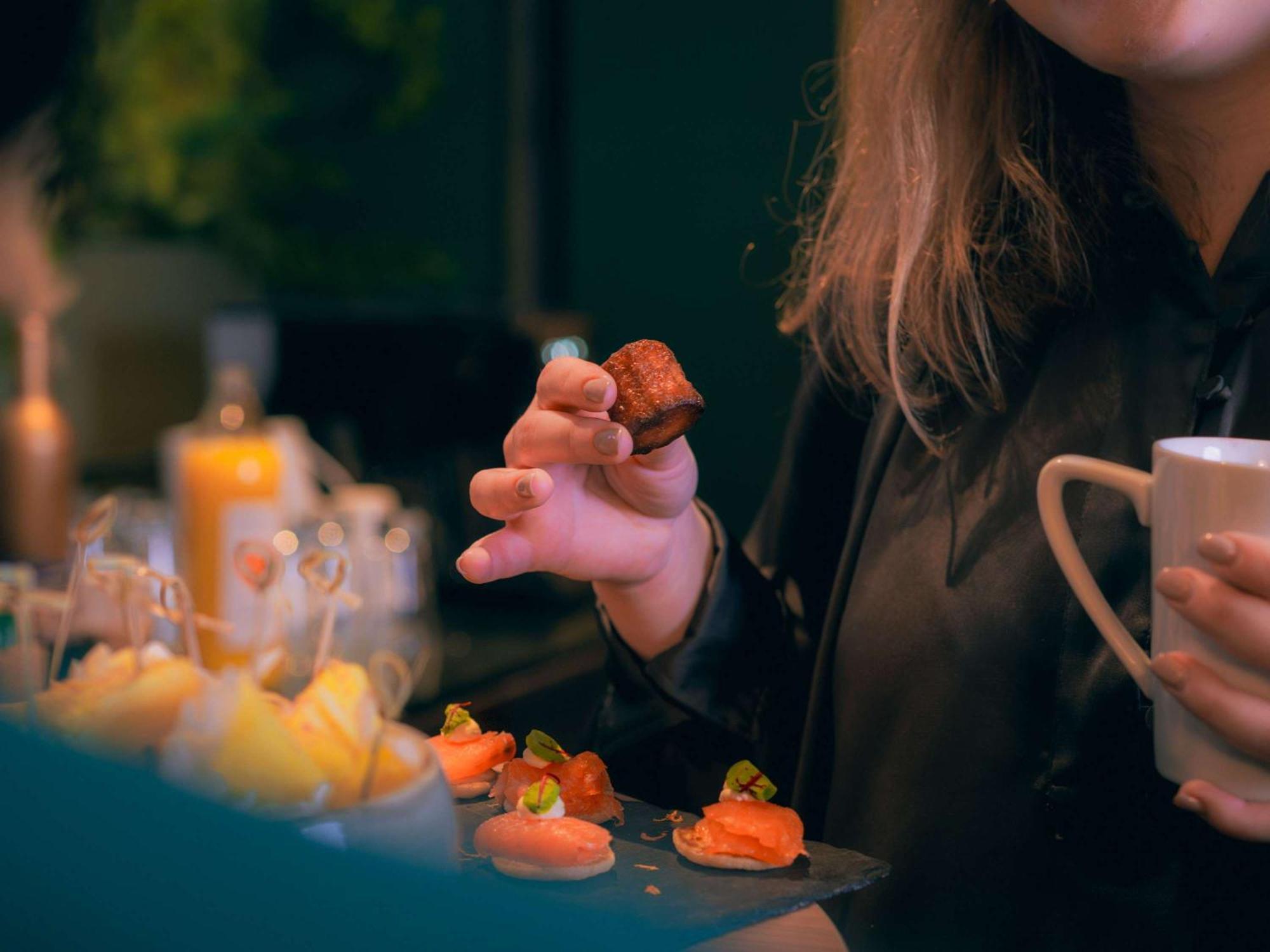Nest Hotel Paris La Defense - Mgallery Collection بيتّو المظهر الخارجي الصورة A woman holding a piece of sushi